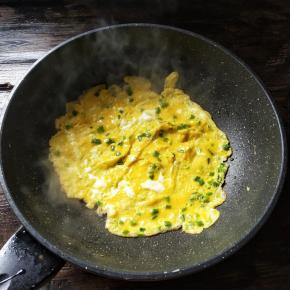 把锅烧热，加少许的油润锅，倒入打匀的蛋液，煎至成型