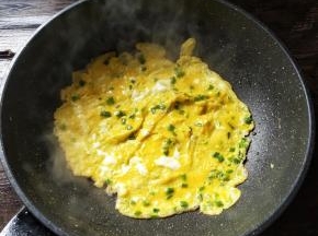 把锅烧热，加少许的油润锅，倒入打匀的蛋液，煎至成型