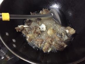 锅中倒入植物油，油比平时炒菜油多一些就可以，烧至七成熟，倒入排骨翻炒，翻炒到排骨变色捞出