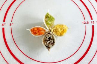 依次填入香菇、胡萝卜、芹菜和鸡蛋，然后捏出个尖角。