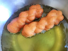 放入麻花生坯，一面炸至变色后再翻面，两面炸至金黄取出控油