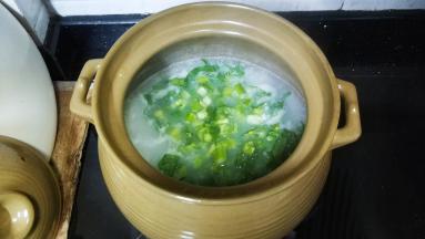 将菜心粒倒入粥里拌均匀煲4分钟