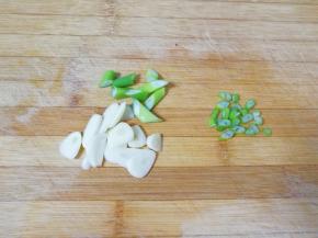 大蒜洗干净切成片，葱叶洗干净切成小段(留一小段切成葱花备用)。