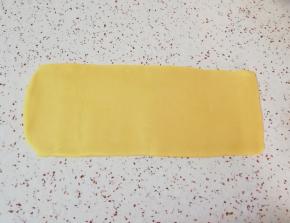 先取一半面团(另外一半盖上保鲜膜，防止风干)，擀成长方形的面片(擀制的过程中可以借助刮刀将面片裁成长方形，裁下来的边角料继续放在面片中间进行擀制)。