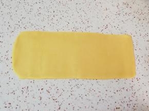 先取一半面团(另外一半盖上保鲜膜，防止风干)，擀成长方形的面片(擀制的过程中可以借助刮刀将面片裁成长方形，裁下来的边角料继续放在面片中间进行擀制)。