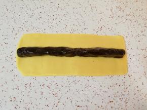 取一半的枣泥馅搓成长条状，放在面片的中间。