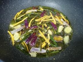 下入准备好的小葱叶、洋葱、生姜、胡萝卜和所有的香辛料，小火炸至所有食材微微焦黄(需要8–10分钟左右)，全部捞出不要。