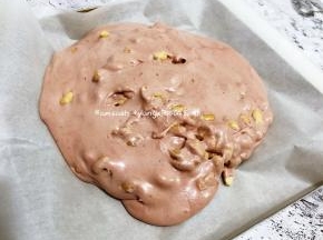 最后准备一个烤盘，铺上油纸，把糖倒出来在油纸上整形，用折叠的方式把所有的材料都混合均匀