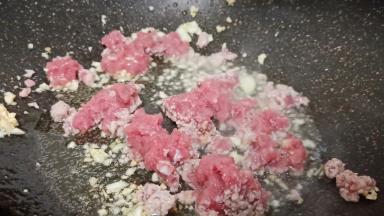 热锅热油炝香蒜末，放猪肉末翻炒至变色。