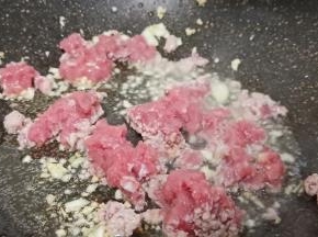 热锅热油炝香蒜末，放猪肉末翻炒至变色。
