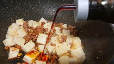 豆腐放进去、调入少许生抽用锅铲翻拌均匀。