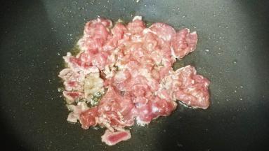 锅里热油，放入牛肉片铺平，煎至微黄