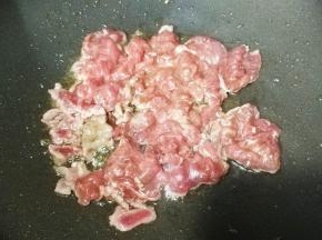 锅里热油，放入牛肉片铺平，煎至微黄