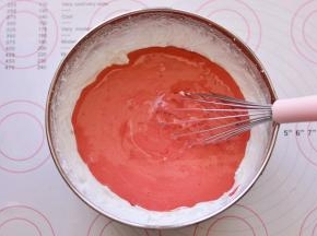 然后将混合好的面糊全部倒入剩余的蛋白霜里，刮刀画Z字形快速翻拌均匀。