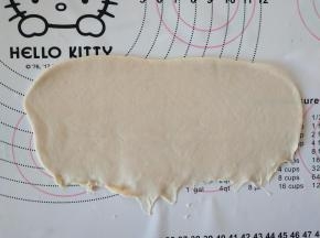 取面团擀成椭圆形，翻面，压薄底边。