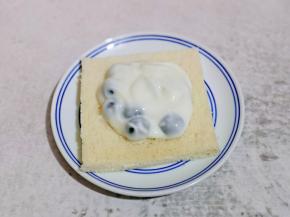 取一片吐司，放上拌好的蓝莓酸奶。