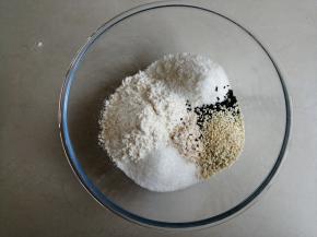 将燕麦片、蛋糕粉、椰蓉、芝麻、糖和盐都倒入和面盆里
