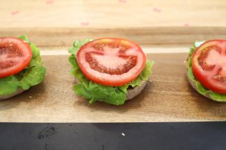 生菜洗净擦干，番茄切成薄片，依次放在汉堡胚上面。