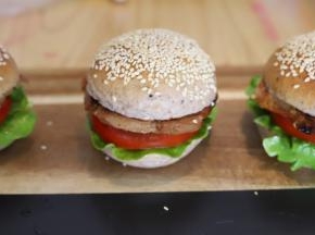 猪肉用刀背轻敲，放入黑椒酱、盐、料酒等配料腌制2小时以上，将腌制好的猪扒煎至双面金黄出锅，放在汉堡胚上，组装好整个汉堡。