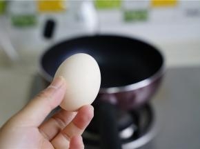 然后锅里加少许油，将鸡蛋打入，煎至凝固。