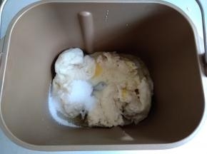 将发酵好的中种撕成小块放入面包桶，倒入水、炼奶、蛋液、糖和盐