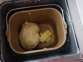 第一次和面结束后，加入切成小块的黄油
