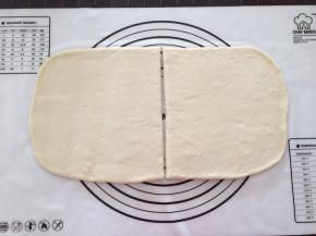 拿出排气擀成长方形面片，中间切半，表面刷一点水