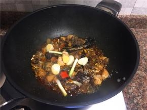 放入葱头、大蒜、生姜和八角翻炒片刻。