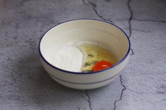 调脆炸糊，把鸡蛋、淀粉放在较大的容器里。