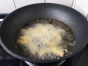 旺火置锅，注入大量的食用油，油温烧至六成热，将鱼条蘸匀稠糊下入。