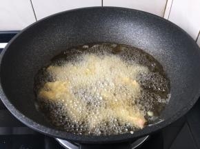 旺火置锅，注入大量的食用油，油温烧至六成热，将鱼条蘸匀稠糊下入。