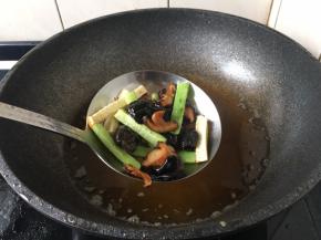 将冬菇、木耳、黄瓜、冬笋放入漏勺里，用热油汆一下备用。