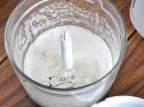 绞肉机里装上打蛋器配件，将蛋清倒入，里面放一部分糖，装配好后先搅打几秒，起泡后，第二次加糖。