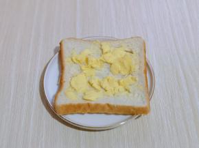 首先取一片吐司，抹上黄油，我用的是涂抹黄油，如果没有这种，把黄油融化后再涂也可以。