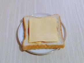 芝士片去掉外衣，平铺在火腿上。