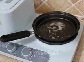 东菱早餐机的煎锅放入黄油，小火加热倒黄油融化。