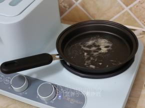 东菱早餐机的煎锅放入黄油，小火加热倒黄油融化。