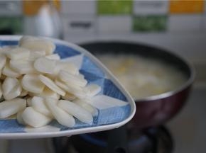 煮至汤底开，食材煮至出味，再将年糕片下锅同煮。