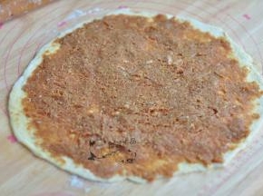 将肉馅抹在面皮上，抹匀。