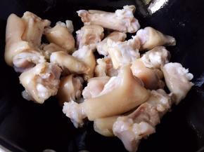 油锅烧热，放入猪蹄块煸炒片刻