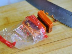 将遇见麻辣先生火锅底料，取一块打开包装，切下一部分。