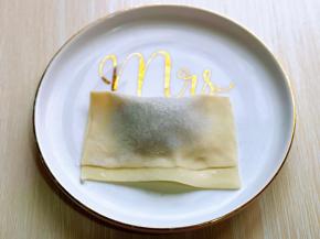 将馄饨皮从上往下对折，周边一圈压紧，如图。