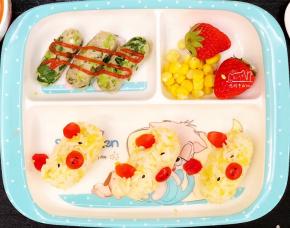 摆盘啰，饭团用小番茄切出猪猪的耳朵和嘴巴，眼睛和鼻孔用黑芝麻装饰。有小棠菜鱼肉肠，玉米和草莓，营养均衡。