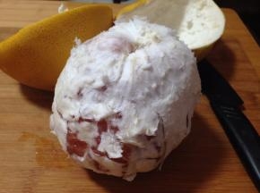 用刀在柚子表面横着划一圈，剥下柚子皮