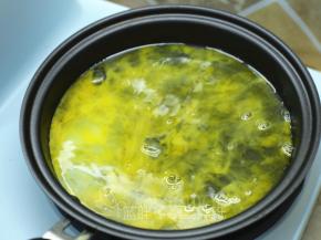 将一个鸡蛋磕入东菱早餐机的煎盘中，小火加热。