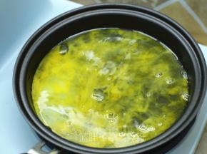 将一个鸡蛋磕入东菱早餐机的煎盘中，小火加热。