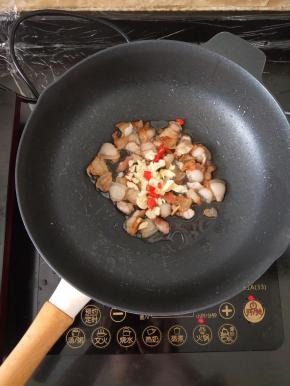 小火煎至出油，有点焦黄。然后放入辣椒和蒜头，煸出香味。