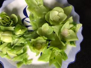 把浸泡凉的白菜茎捞出沥干水分，再用剪刀把每根茎剪成三角形，成莲花状，摆好盘中