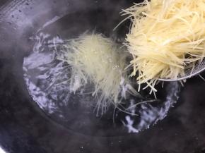 放入土豆丝汆烫至变色即可