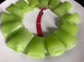 把莴笋片卷成卷摆入盘边周围